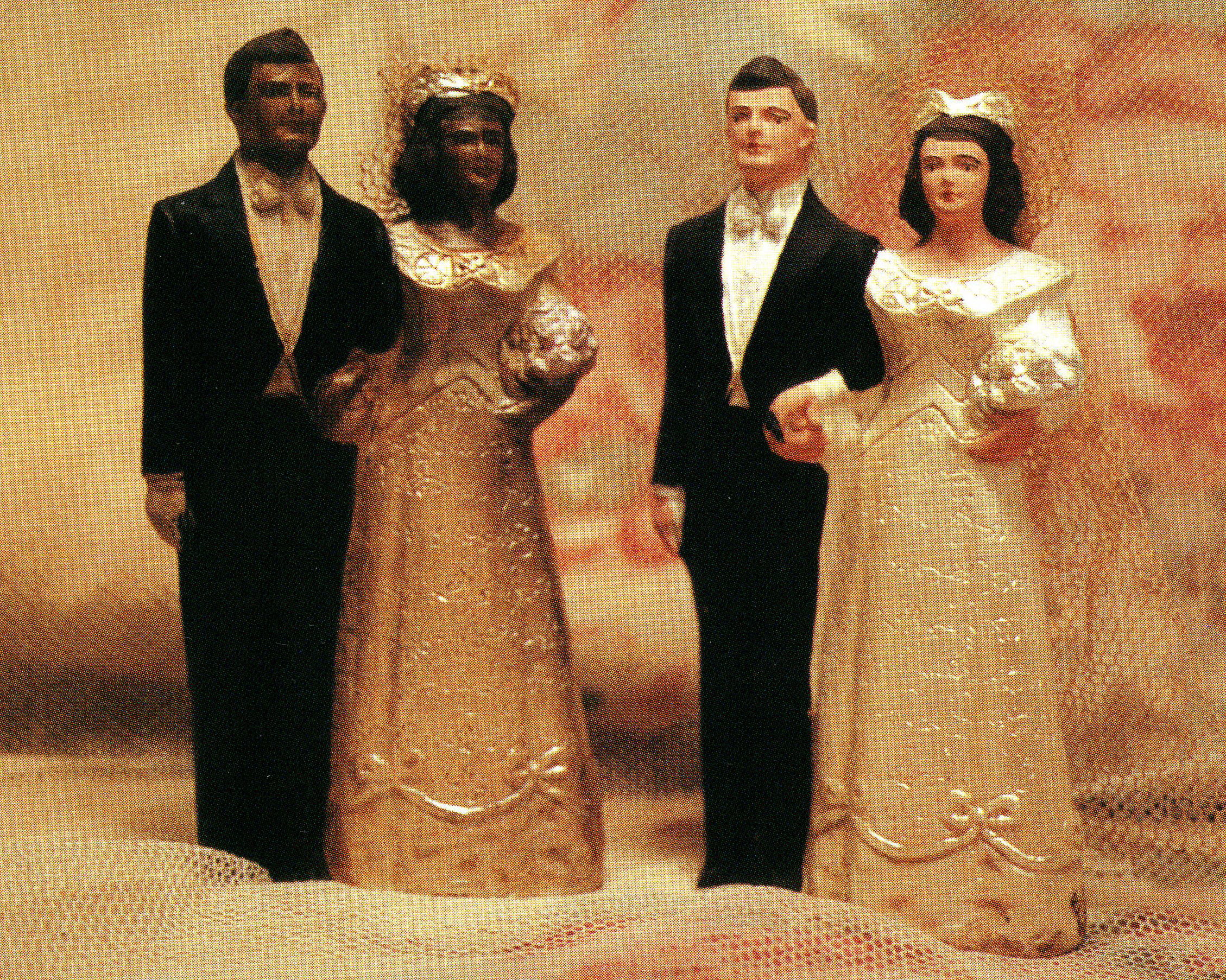Figures of a Black bride and groom and a white bride and groom, identical except for skin color