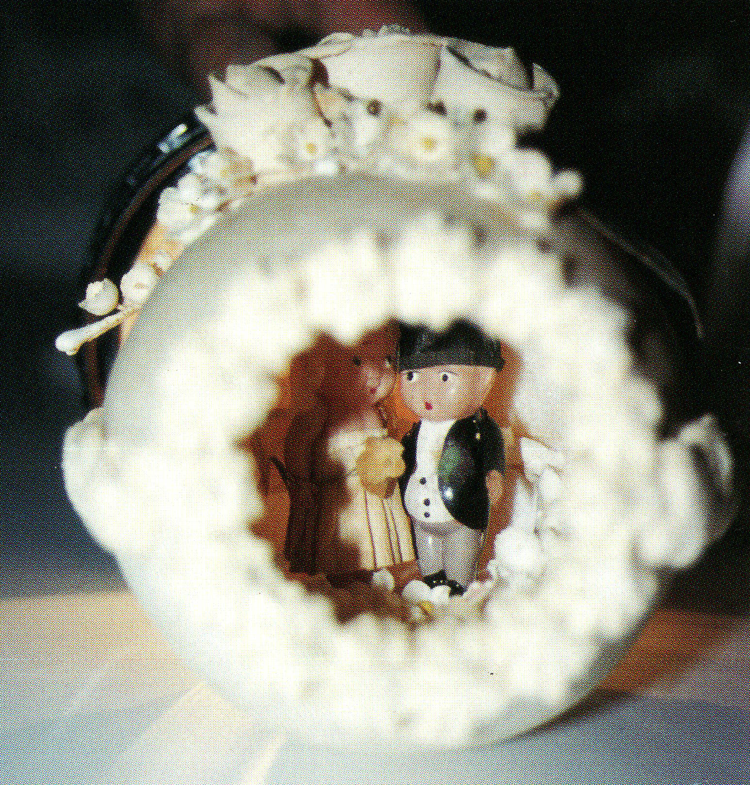 Childlike bride and groom figures inside a sugar egg with flowers on top