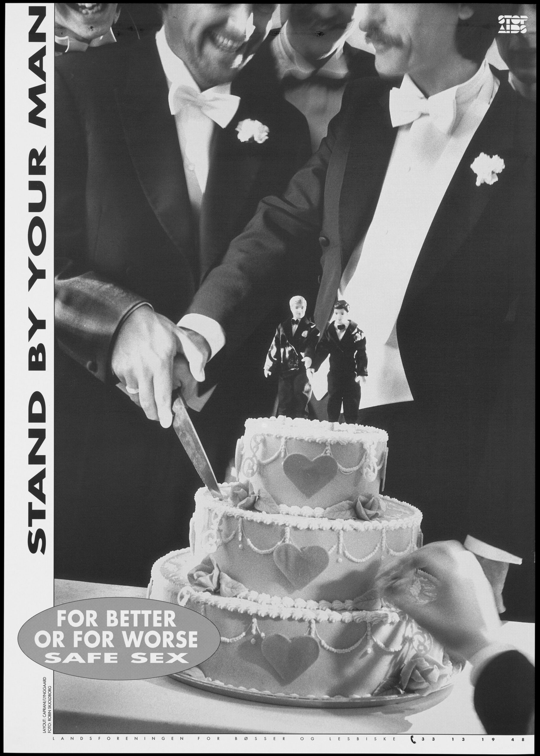 Two smiling men in tuxedos both hold a knife that cuts into the wedding cake in front of them