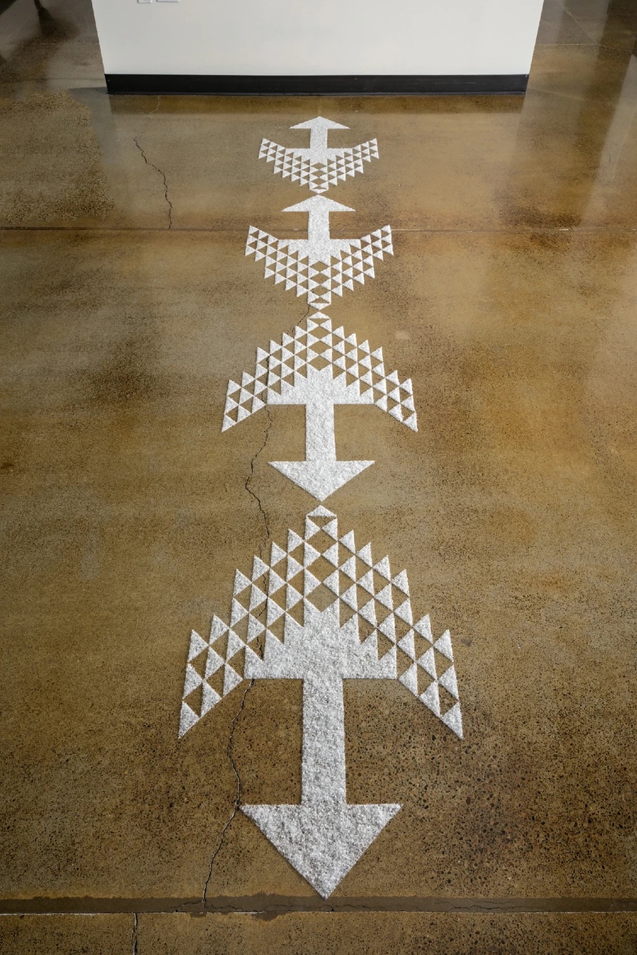 intricate white salt arrow patterns on a wood floor