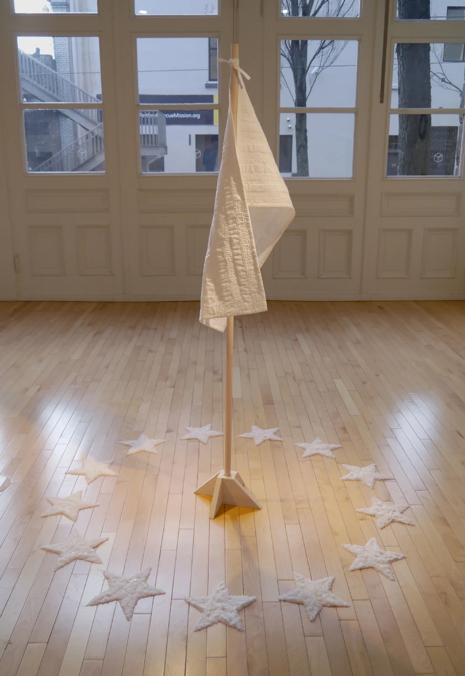 photo of a white flag on a short flag stand surrounded on the floor by salt stars
